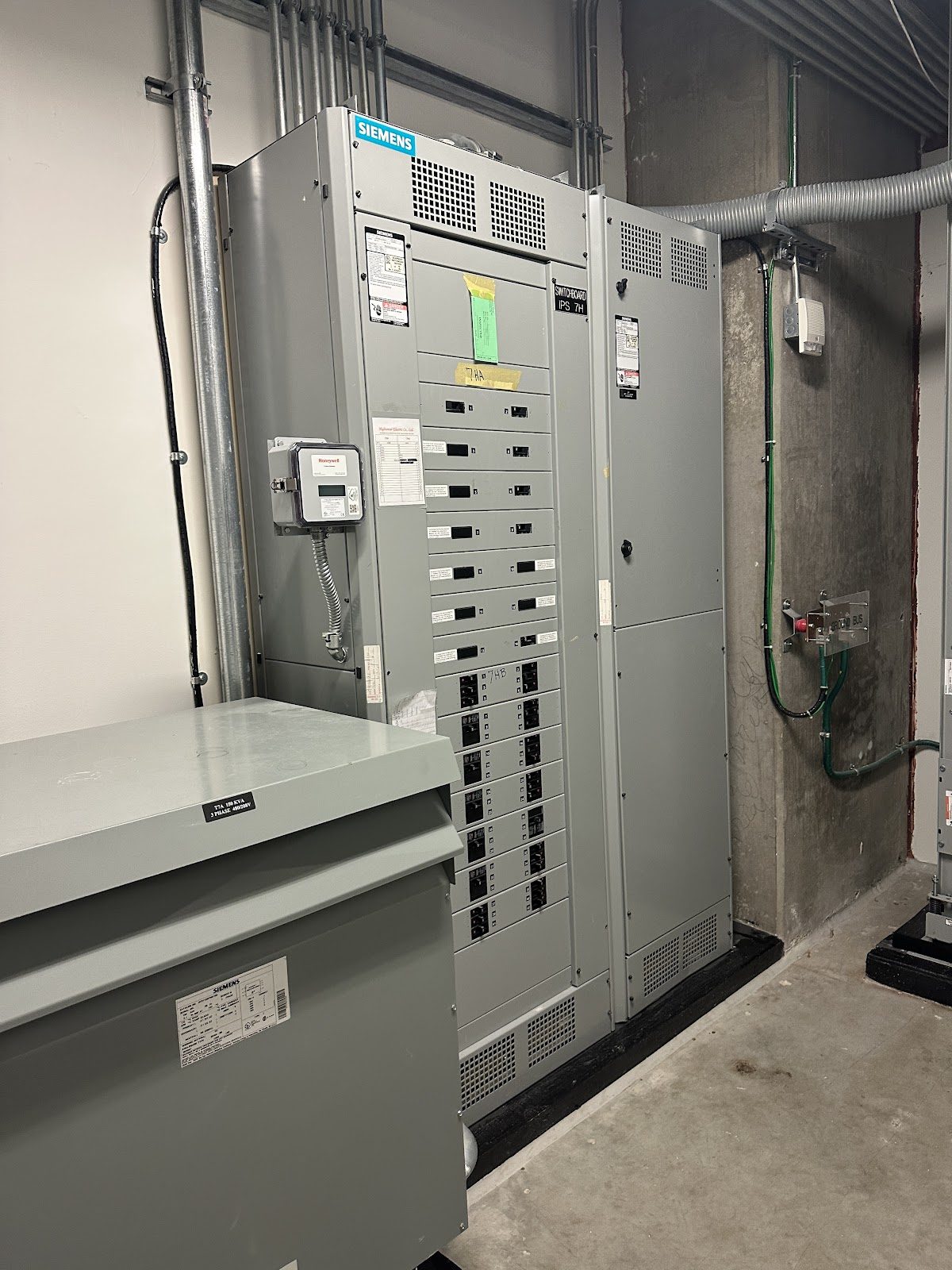 A Siemens electrical switchboard and Honeywell meter in a commercial electrical room